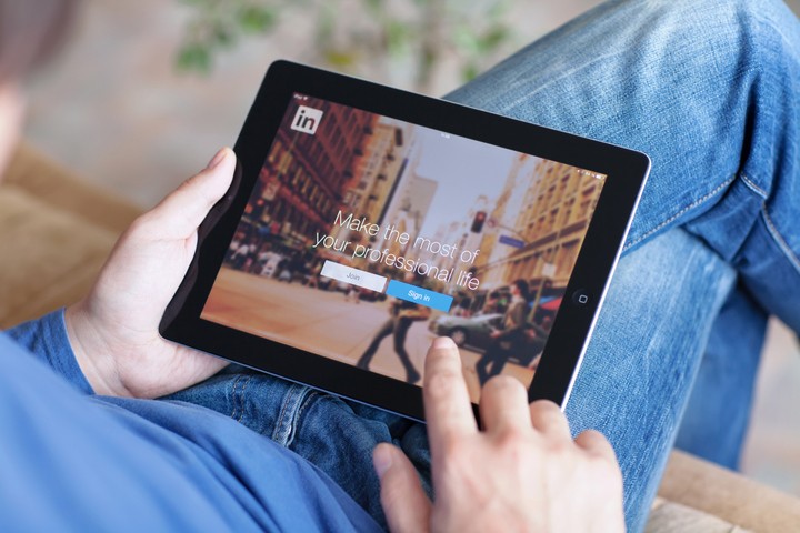 Person using LinkedIn on tablet for professional networking