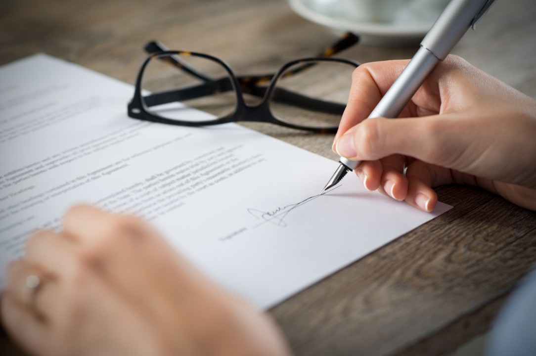 Professional signing a career offer document